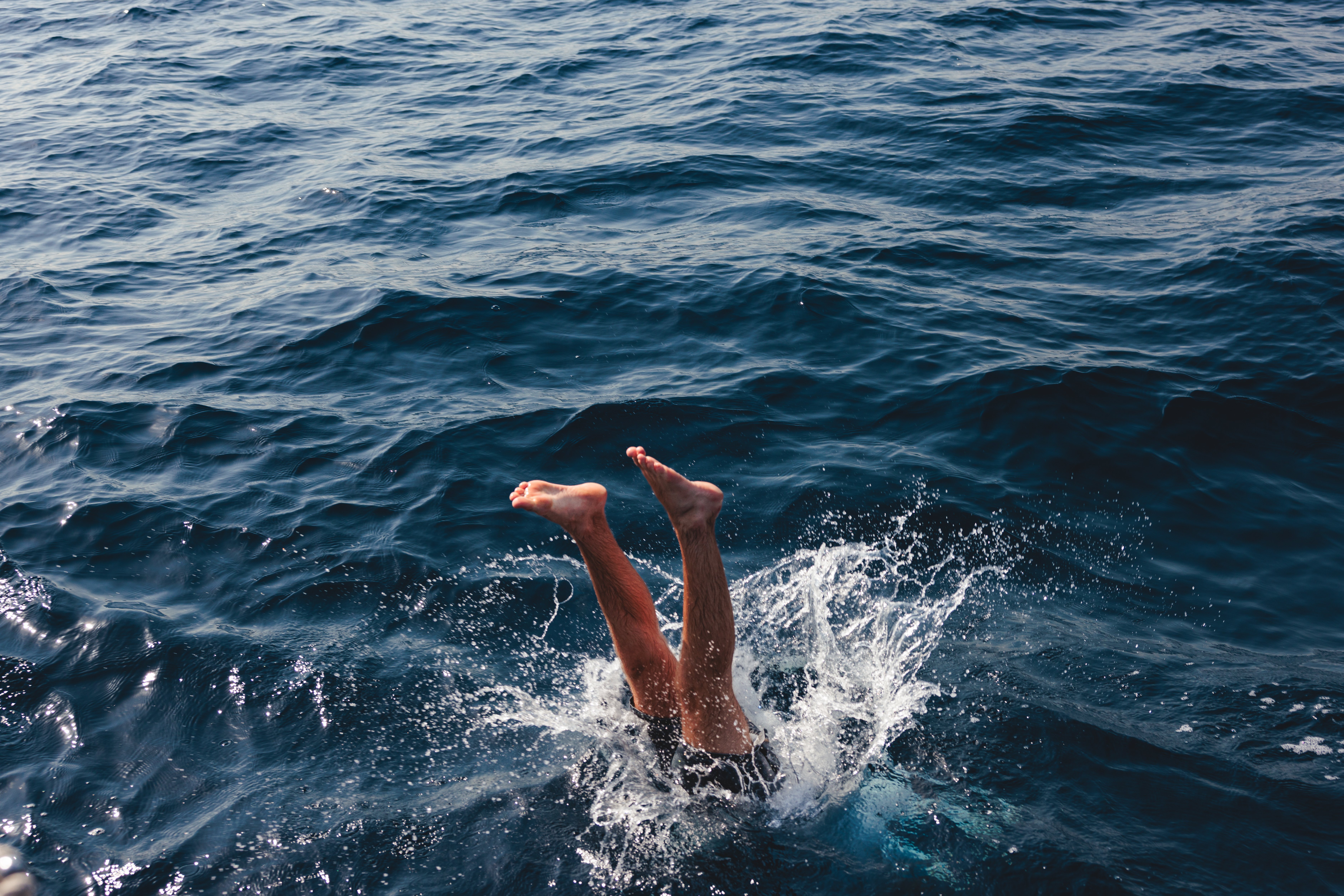 Person diving into the ocean in summer — JECT summer skin care guide